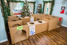 cardboard boxes are arranged in the middle of a room with christmas decorations on the walls