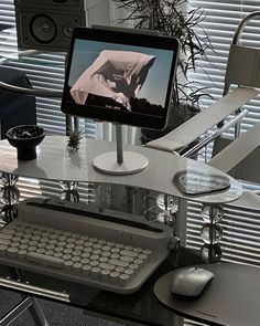 a computer monitor sitting on top of a glass desk next to a keyboard and mouse