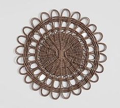 an intricately designed wall hanging made out of brown rattan and wickers