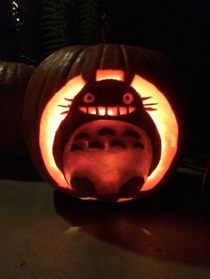 a pumpkin carved to look like a cat with its mouth open and eyes wide open