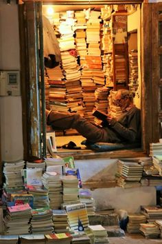 a man sitting in front of a large pile of books