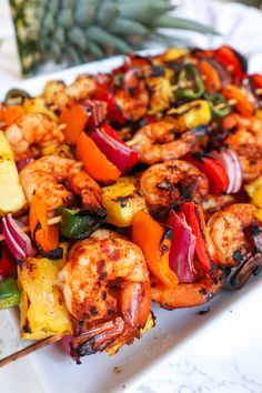 grilled shrimp and pineapple kabobs on a white platter