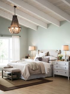 a bedroom with a bed, dresser and lamps in it's centerpieces