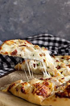 a slice of pizza being lifted from a wooden cutting board