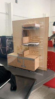 an open cardboard box sitting on top of a table next to a red chair and other items