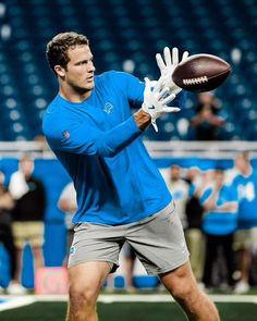 a man holding a football in his right hand and catching it with the other hand