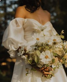 a woman in a white dress holding a bouquet of flowers