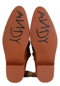 an orange pair of shoes with the words andy written on them and black lettering underneath