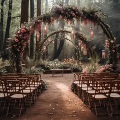 an outdoor ceremony setup with floral arrangements and hanging lanterns in the forest, surrounded by tall trees