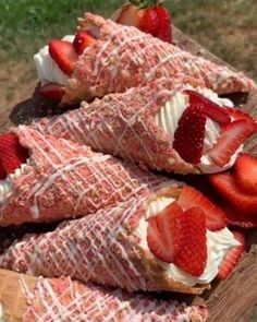 strawberries and whipped cream are arranged on top of an ice cream sundae cone