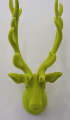 a green stuffed deer head on a white background