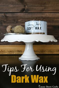 a white cake plate topped with a jar of wax next to a can of soft wax