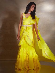 Yellow corset blouse featuring ivory hand embellished camellia florals paired with a fishtail ruffle skirt & georgette organza pallu with a pearl belt.From Shloka Khialani's Winter Sun collection.DELIVERY TIMEPlease allow 6-8 weeks for your outfit to arrive.FABRIC DETAILSGeorgette, Organza, NetProfessional cleaning only. Yellow Corset, Pearl Belt, Corset Blouse, Ruffle Saree, Embellished Belt, Drape Saree, Yellow Saree, Winter Sun, Fashion App