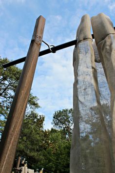 an old wooden pole with sheer curtains hanging from it's sides