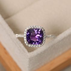 This halo ring features a 8*8mm cushion cut natural amethyst and sterling silver finished with rhodium. Customization is available. It is made by hand, and it will take about 7 days to finish the ring after your payment is completed. Main stone: natural amethyst Amethyst weight: Approx 2.10 ct Metal type: sterling silver finished with rhodium Accent stone: cz Customization is available, I also can make it with 14k solid gold (white or yellow or rose) and diamond accent stone, just feel free to c Cheap Gemstone Rings, Amethyst Ring Engagement, Purple Amethyst Ring, Purple Rings, Jewelry Wedding, Ring Engagement, Halo Ring, Halo Engagement, Amethyst Ring