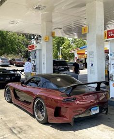 a red sports car parked at a gas station