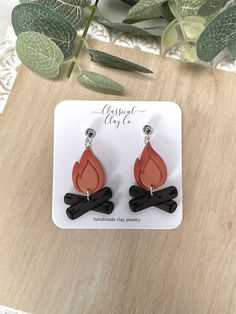 the earrings are made out of wood and have an orange tear shaped design on them