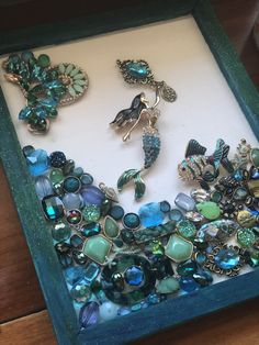 an assortment of jewelry is displayed in a shadow box