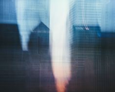 blurry image of two people standing in front of tall buildings with skyscrapers behind them