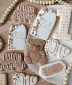 decorated cookies are arranged on a plate with the words happy birthday and a teddy bear