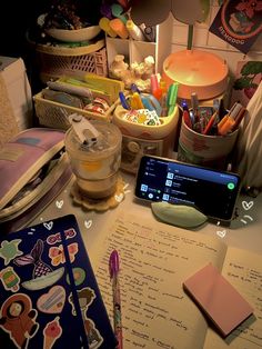 an open notebook sitting on top of a desk next to a cell phone and pen