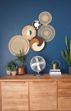 a wooden dresser topped with lots of plants and wicker baskets on top of it