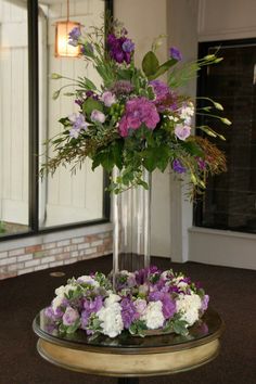 a vase filled with purple and white flowers on top of a table