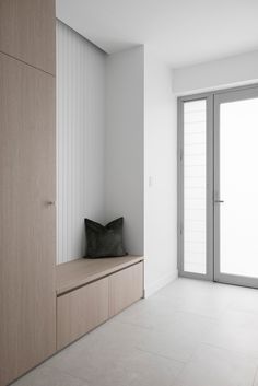 an empty room with a bench and sliding glass doors