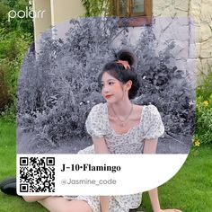 a woman sitting on the ground in front of some bushes and flowers with qr code for j - 10 flamingo