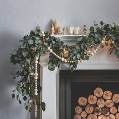 a fireplace decorated with greenery and candles