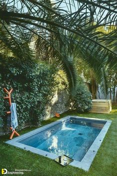 a person standing in front of a pool surrounded by grass and palm trees, reaching up into the air