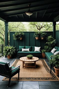 an outdoor living room with green furniture and potted plants