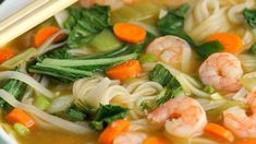 a bowl of shrimp noodle soup with chopsticks