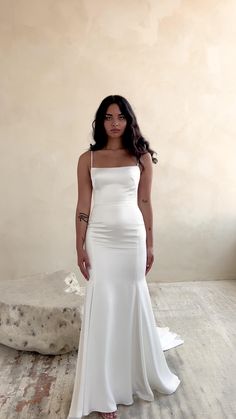 a woman in a white dress posing for the camera