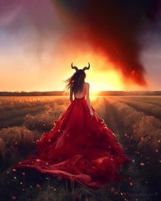 a woman in a red dress is standing in the middle of a field with an animal's horns on her head