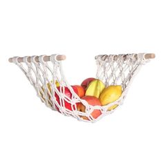 a basket filled with fruit sitting on top of a white wall