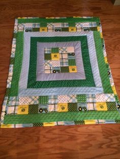 a green and white quilted table topper on a wooden floor with wood floors