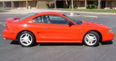 an orange sports car parked in a parking lot