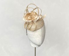 This chic champagne looped headpiece with it's silk flower and veiling will make a great addition to any wedding or race day outfit.  Colour can be matched for your requirements.  Free express delivery email rubybosebridal @ gmail .com and I will sort that out for you   Handmade using the highest quality materials.  The disc is approx 15 cm in diam Secured with elastic in a choice of colours to blend your hair colour. Each piece is handmade by me, for you, using the highest quality materials. If you have a specific date you need the headpiece please get in touch and I will ensure you receive in good time. If you would like the piece to be made to match your outfit, or adapted please contact me (a swatch can be sent or matched to your required colour) Presented in a branded hat box.  Please Beige Mini Hat Headband For Weddings, Adjustable Beige Headpieces For Wedding, Beige Wedding Headband, Adjustable Wedding Fascinator With Handmade Flowers, Handmade Flowers Adjustable Fascinator For Wedding, Wedding Fascinator With Handmade Flowers, Cream Mini Hats With Handmade Flowers For Wedding, Beige Fascinator For Wedding At Kentucky Derby, Adjustable Mini Hats With Handmade Flowers For Wedding