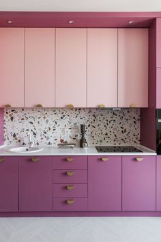 a kitchen with pink cabinets and white counter tops