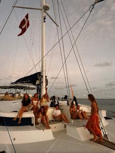 several people sitting on the deck of a sailboat