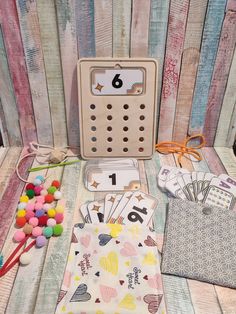 a wooden table topped with lots of cards and other items on top of eachother