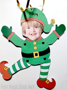 a child's christmas ornament hanging on a wall with scissors and paper