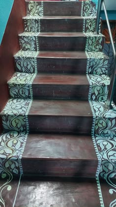 the stairs are painted with an intricate pattern and hand - painted in brown, blue, green and white