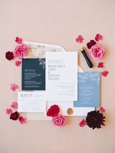 the wedding stationery is laid out on top of each other, with pink flowers