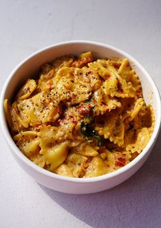 a white bowl filled with pasta and sauce