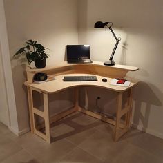 a corner desk with a computer on it and a lamp in the corner next to it