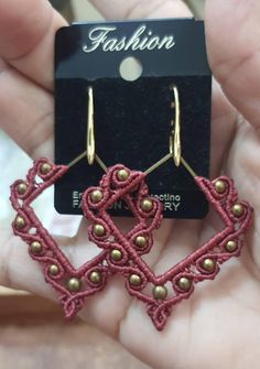 a pair of earrings is shown in front of a card with the word fashion on it