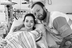 a man and woman laying in a hospital bed next to each other with medical equipment around them