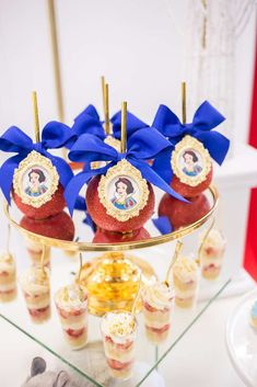 desserts are arranged on a gold tray with blue bows